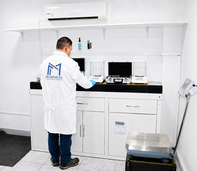 Técnicos de METRINDUST operando equipo de medición en laboratorio de calibración